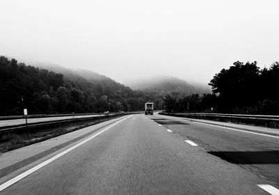 Road passing through mountains against clear sky