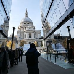 Rear view of people outside building against sky