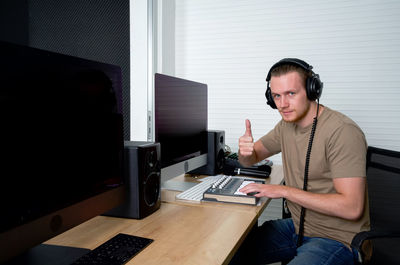 Young man using mobile phone while sitting on table