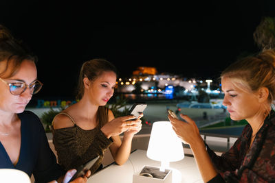 Young woman using mobile phone at night