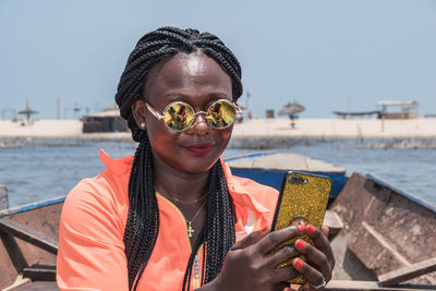 Portrait of smiling woman in sea against sky