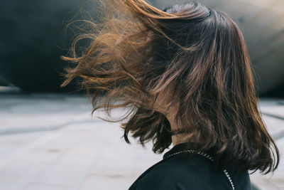 Side view of woman with tousled brown hair