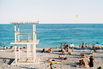 People on beach against clear sky