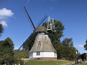 Low angle view of traditional windmill against sky