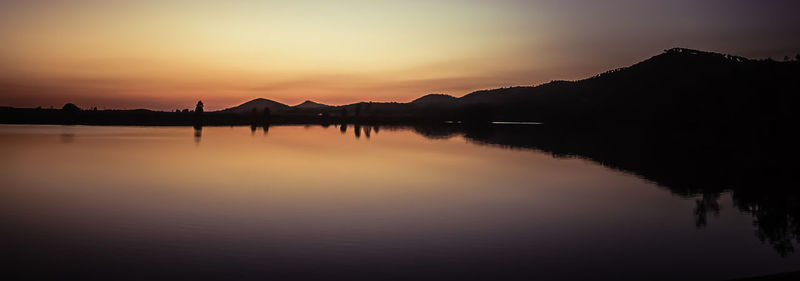 Scenic view of lake against sky at sunset