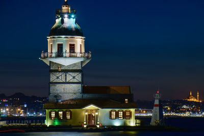 Illuminated maiden tower building against sky at night