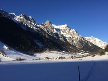 Scenic view of snowcapped mountains against clear blue sky