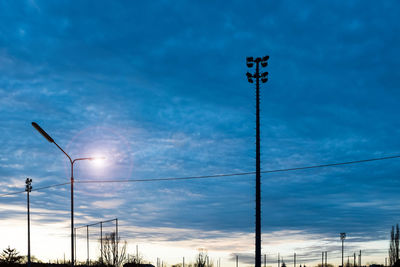 Low angle view of power lines against cloudy sky