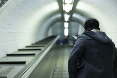 Rear view of man standing at subway station