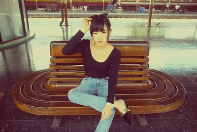 Woman looking away while sitting on bench