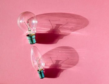 High angle view of light bulbs on pink table