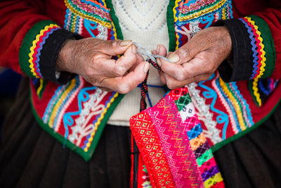 Close-up of woman hand holding multi colored umbrella