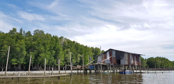 Scenic view of river by buildings against sky