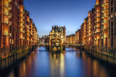 Bridge over canal amidst buildings in city