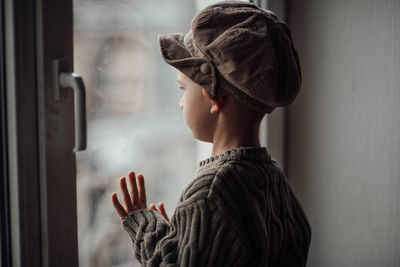 Boy looking away through window