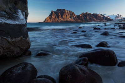 Rocks on sea shore against sky