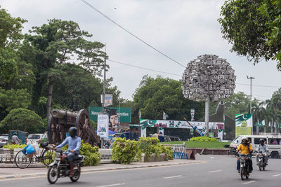 People riding bicycle on road in city