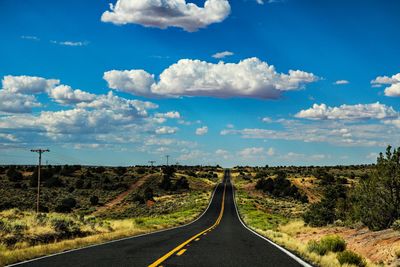 Empty road along landscape against sky