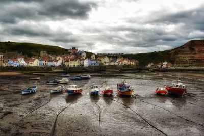 Boats moored on beach against sky