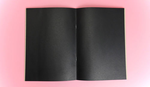 High angle view of book against pink background