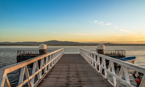 Pier over sea against sky during sunset