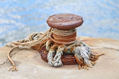 Close-up of rope tied on rusty pier