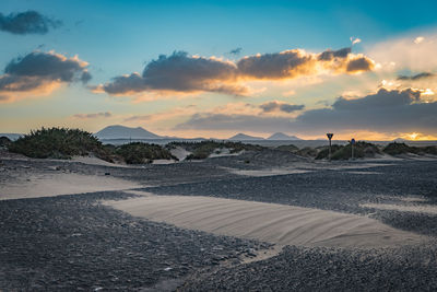 Scenic view of land against sky during sunset