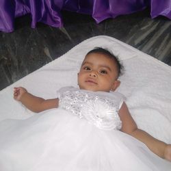 Portrait of cute baby lying on bed