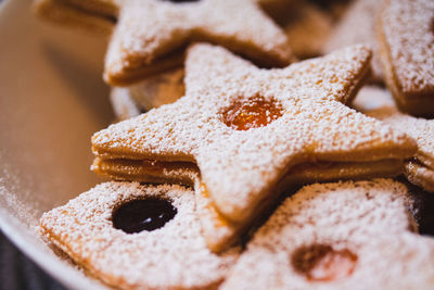 Close up of a star-shaped linzer cookie with marmalade and powdered sugar