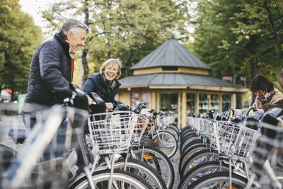 Senior people taking rental bikes at parking lot