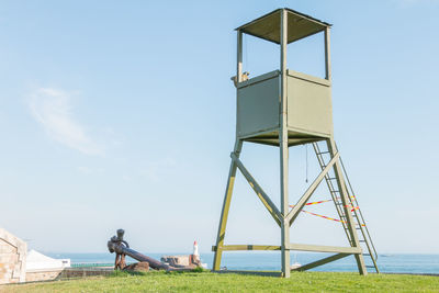 Man sitting on field against sky