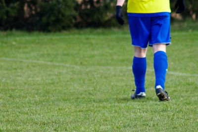 Low section of soccer player walking on field