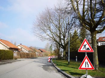 Signboards at roadside in town against sky