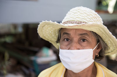 Portrait of senior woman wearing sun hat and surgical mask