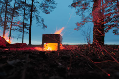 Panoramic view of illuminated fire against sky at sunset