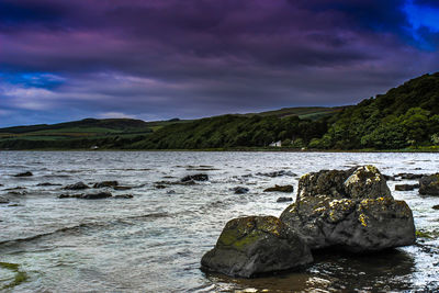 Rocks by sea against sky