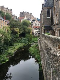 Arch bridge over canal amidst buildings against sky