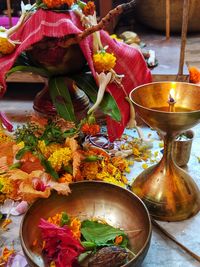 High angle view of lit oil lamp by religious offering 