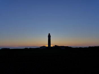 Silhouette of lighthouse against sky during sunset