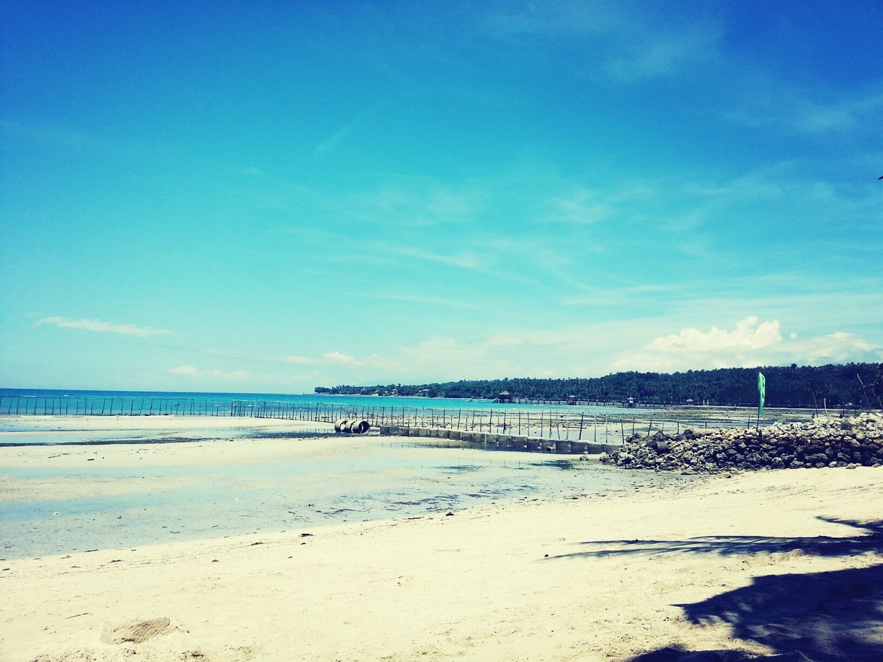 beach, sea, water, sand, shore, tranquility, tranquil scene, blue, scenics, sky, beauty in nature, horizon over water, nature, coastline, idyllic, pier, calm, outdoors, day, non-urban scene