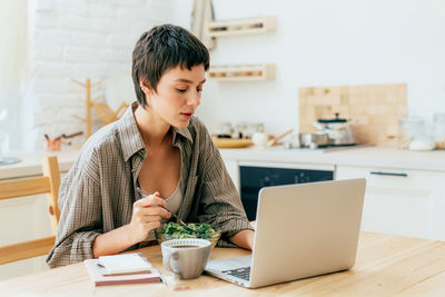 Young woman using laptop at table