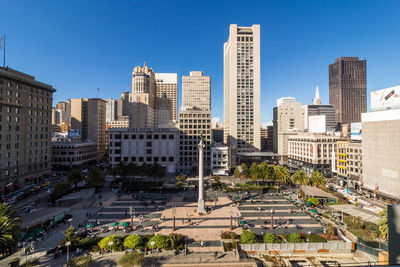 Buildings in city against clear blue sky