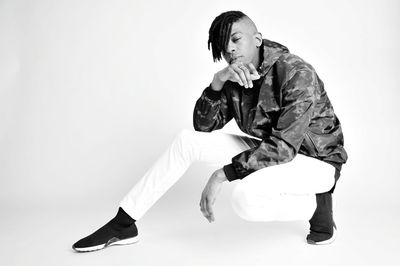 Young man looking away over white background