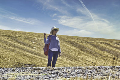 Rear view of woman on field against sky