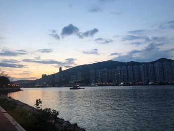 Scenic view of sea by city buildings against sky