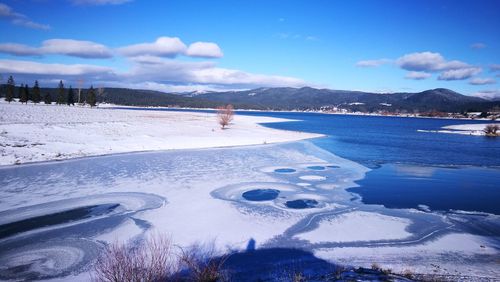 Scenic view of frozen lake against sky during winter