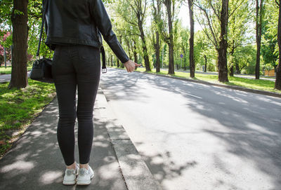 Low section of man walking on road