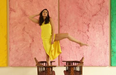 Full length portrait of woman against wall