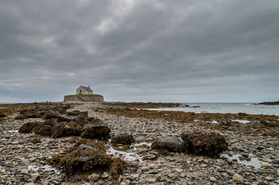 The 12th century st cwyfan church, on the small tidal island of cribinauon, on anglesey.