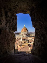 Buildings in city seen through cave